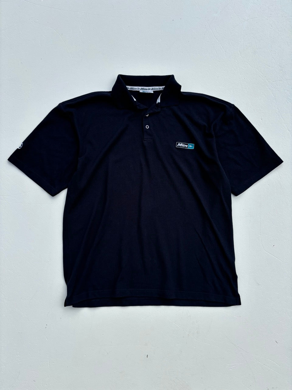 An image of a Mitre Navy Polo Shirt in size L.